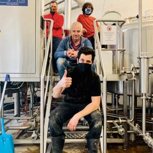 Belleville x Mondo Collab – Introducing Hey Neighbour. The Belleville and Mondo brewing teams pose for a photo on the steps within the Belleville Brewery.