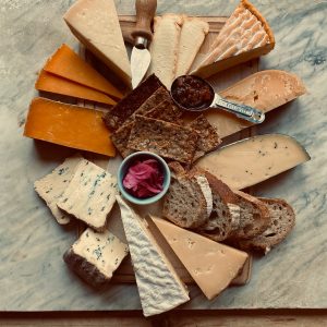 Christmas Beer and Food Pairings. Photograph of a cheeseboard with a selection of crackers, chutneys and assorted cheese