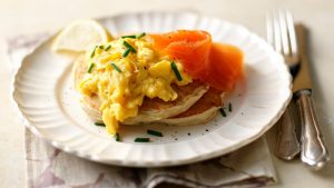 Christmas Beer and Food Pairing - A photograph of buckwheat blinis with scrambled eggs and smoked salmon on a white decorative plate