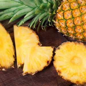 Introducing Philly Buster IPA. A photograph of freshly chopped pineapple on a wooden table