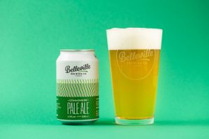 Deep Dive Into Commonside Pale Ale. A photograph of Commonside pale ale and a pint of beer on a green background