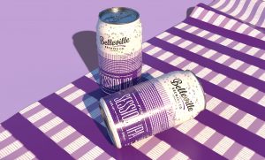 Deep Dive into Picnic Session IPA. Vector image of two purple cans of Picnic Session IPA laid out on a purple, checkered pattern picnic blanket.